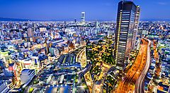 Vista notturna dello skyline di Osaka con edifici illuminati.