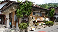 Un edificio tradizionale a Yudanaka Onsen circondato da piante.