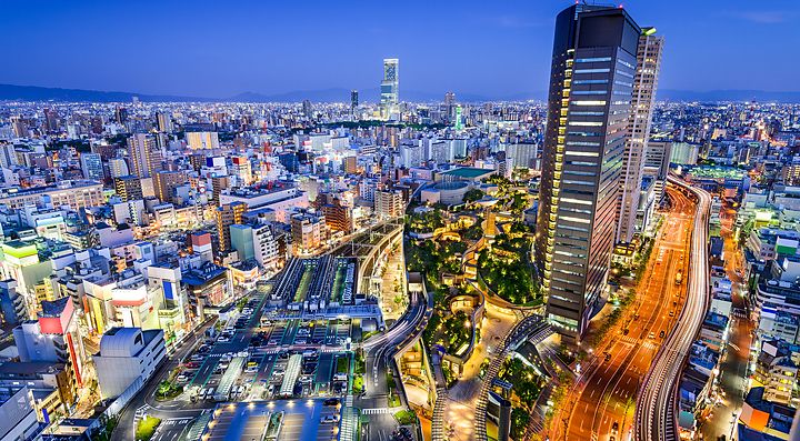 Vista notturna dello skyline di Osaka con edifici illuminati.