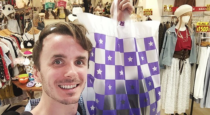 Interno di un negozio a Tokyo con Marco Togni che tiene una busta.