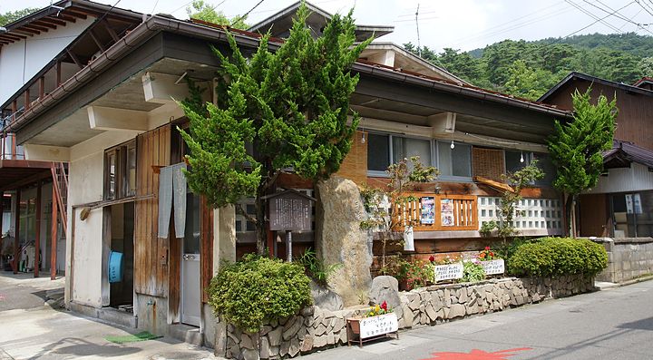 Un edificio tradizionale a Yudanaka Onsen circondato da piante.