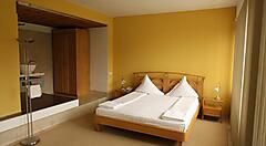 Camera moderna dell'Hotel Central a Timișoara con letto matrimoniale e arredi eleganti.
