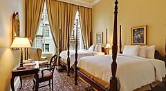 Camera elegante al Pelham Hotel di New Orleans con letti a baldacchino.