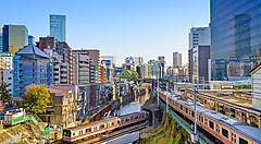 Treni in transito tra grattacieli e palazzi nel paesaggio urbano di Tokyo.