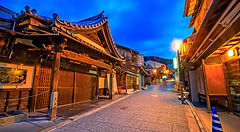 Strada di Gion a Kyoto, con case tradizionali illuminate di sera.