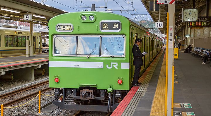 Treno locale JR, di colore verde, diretto a Nara, fermo in stazione a Kyoto.