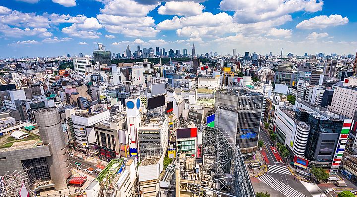 Skyline urbano di Shibuya, Tokyo, con edifici moderni e cielo azzurro.