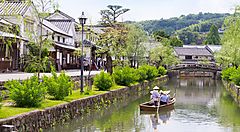 Canale storico di Kurashiki con barca e edifici tradizionali.