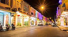 Strada illuminata nel centro storico di Phuket con edifici colorati di notte.