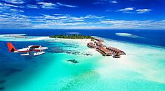 Atollo tropicale alle Maldive con idrovolante e mare cristallino.