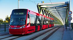 Tram rosso attraversa un ponte moderno a Bratislava.