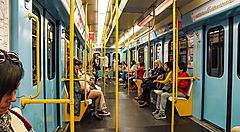 Interno di un vagone della metropolitana di Milano con passeggeri seduti.