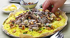 Piatto tradizionale giordano con riso giallo, carne e mandorle.