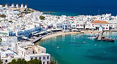 Vista panoramica su Mykonos con case bianche e mare cristallino.
