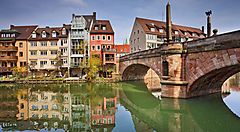 Ponte e edifici storici riflessi sull'acqua a Norimberga.