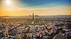 Vista panoramica di Parigi al tramonto con la Torre Eiffel al centro.