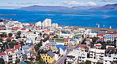 Veduta aerea di Reykjavik con case colorate e mare sullo sfondo.