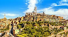 Panorama di Siena con edifici storici e cielo azzurro.