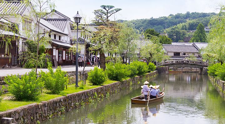 Canale storico di Kurashiki con barca e edifici tradizionali.