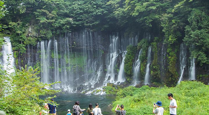 Cascata di Shiraito in Giappone circondata da vegetazione verde.
