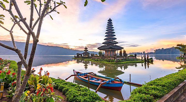 Tempio Ulun Danu Bratan a Bali, con un lago e una barca in primo piano.