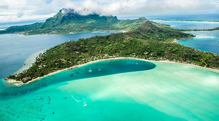 Vista aerea di Bora Bora con mare turchese e isole verdeggianti.