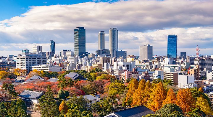 Skyline di Nagoya con grattacieli e alberi colorati in autunno.