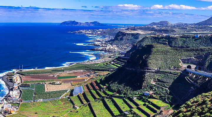 Costa panoramica delle Canarie con mare e colline terrazzate.