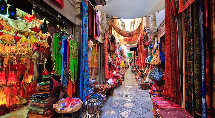 Un colorato mercato coperto a Granada con tessuti e lampade appese.