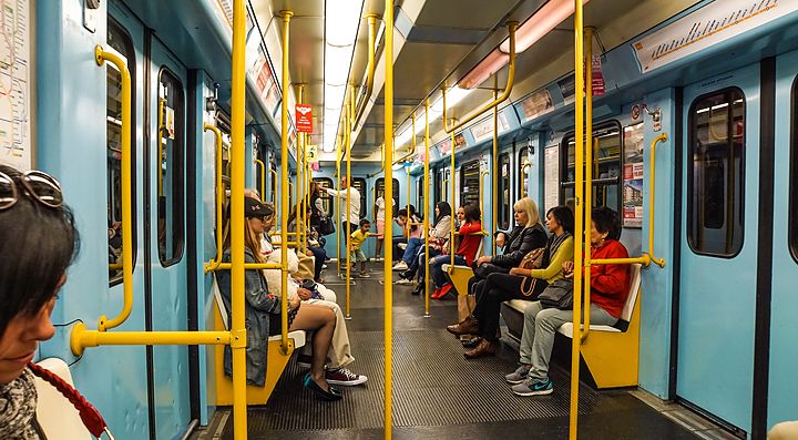 Interno di un vagone della metropolitana di Milano con passeggeri seduti.