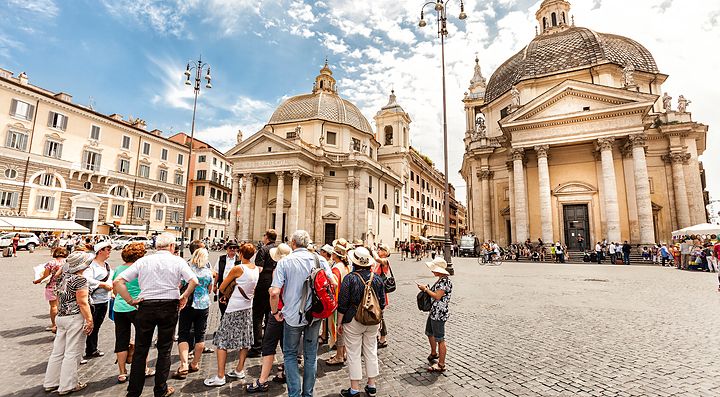 Turisti a Piazza del Popolo a Roma con chiese gemelle sullo sfondo.