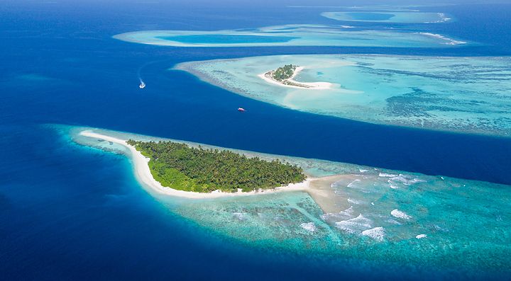 Arcipelago delle Maldive con isole tropicali e mare turchese.