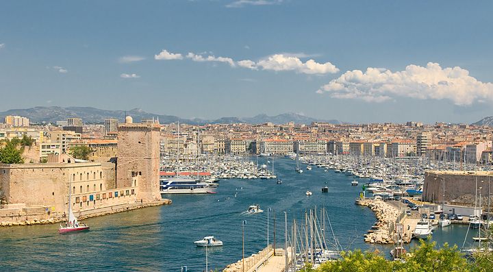 Porto di Marsiglia con barche a vela e edifici storici.