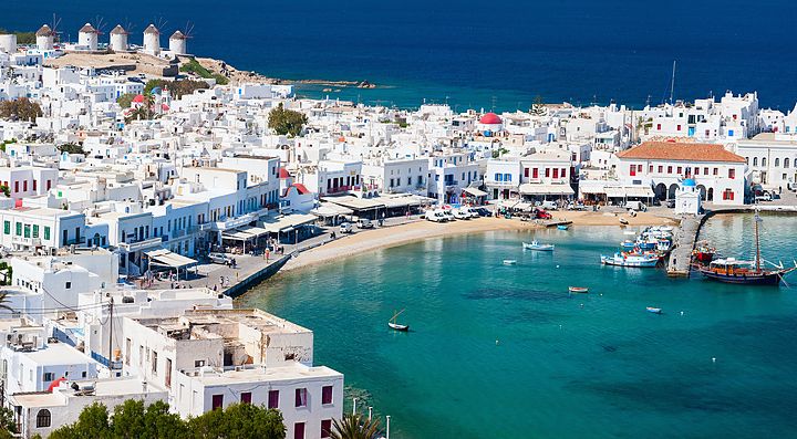 Vista panoramica su Mykonos con case bianche e mare cristallino.