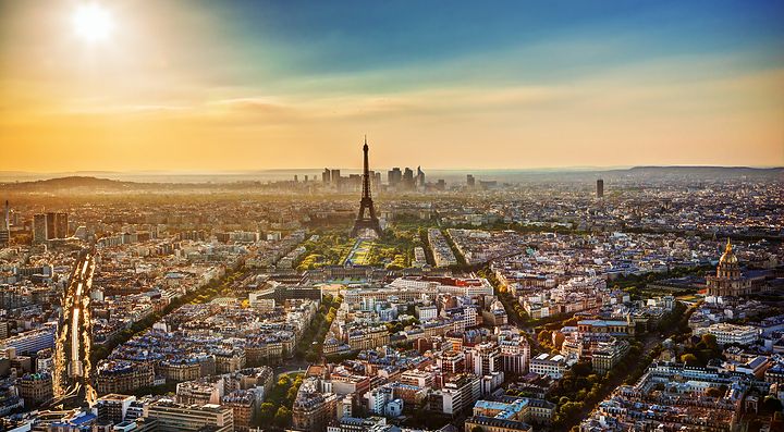 Vista panoramica di Parigi al tramonto con la Torre Eiffel al centro.