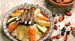 Piatto di couscous tunisino con verdure e costine di agnello.