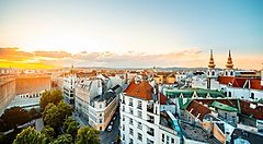 Panorama di Vienna al tramonto con edifici storici e torri.