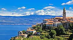 Veduta del paesaggio costiero dell'isola di Krk con edifici storici e mare.