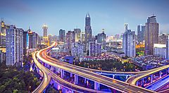 Panorama urbano di Shanghai con grattacieli e strade illuminate.