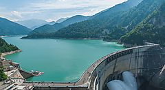 Diga di Kurobe in Giappone con montagne e lago sullo sfondo.
