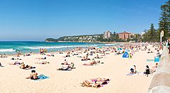 Spiaggia affollata a Manly, Australia, con bagnanti e vista sul mare.