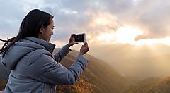 Una persona fotografa il tramonto dal monte Hangetsuyama.