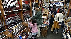 Negozio di coltelli a Tokyo con clienti che osservano i prodotti esposti.