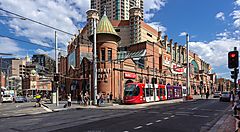 Tram rosso davanti a Paddy's Market a Sydney, su una strada trafficata.