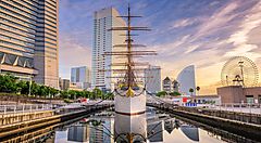 Nave storica Nippon Maru ancorata nel parco memoriale a Yokohama, skyline sullo sfondo.