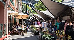 Mercatino all'aperto a Rocks Market, con bancarelle e persone che passeggiano.
