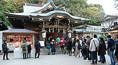 Visitatori in fila davanti a un santuario tradizionale a Enoshima.