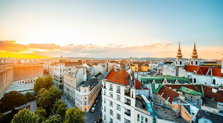 Panorama di Vienna al tramonto con edifici storici e torri.