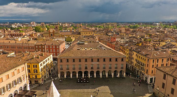 Vista panoramica di Modena con edifici storici e cielo nuvoloso.