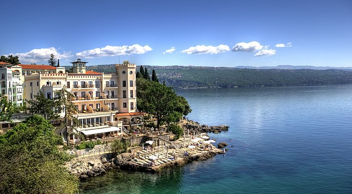 Vista sulla costa con un hotel a Opatija e mare azzurro.